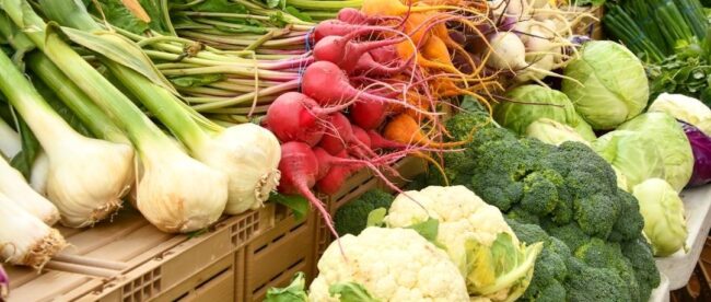 Étal de légumes frais présenté dans une boutique à la ferme